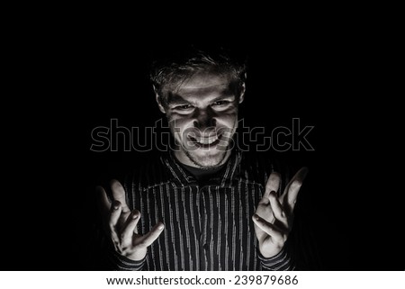 Man portrait with evil look isolated on black background.Face expression