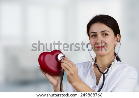 Smiling Female doctor holding red heart and a stethoscope.Medicine,Health care,Hospital.
