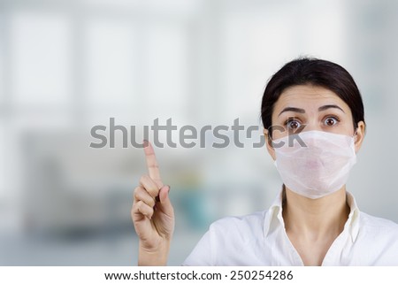 Female doctor with protective mask pointing up.Hospital,Prevention,Stop,Medical,Hospital,Danger.