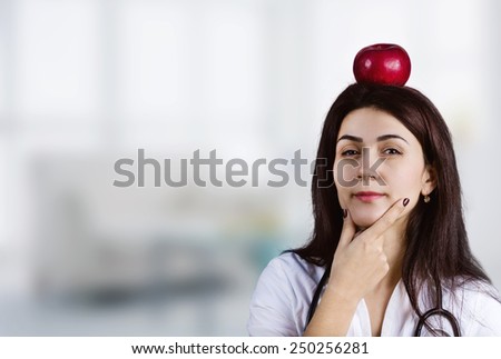 Female Doctor Thinking with an red apple on her head.Thoughtfully.