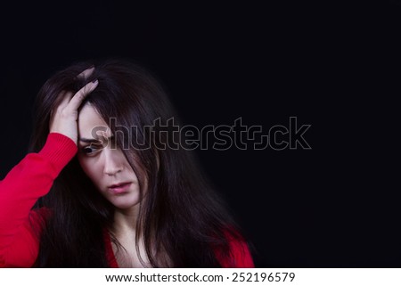 Stressed young women,student portrait, sad, bothered, holding hand on her head isolated on black background.