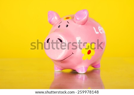 Piggy coin bank on yellow background . Cute white ceramic piggy coin bank. Money savings.Financial security,Personal funds.Spring.