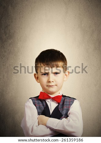 Serious,Stubborn,sad,upset  little boy,child  isolated over yellow background.Facial expression