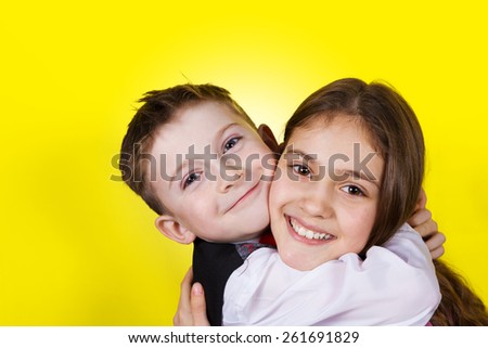 Happy brother and sister hugging over yellow background.Love ,Family,Friendship