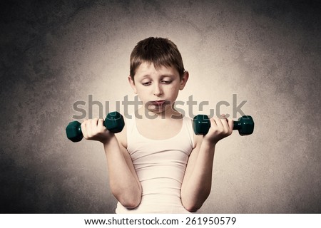 Tired,Bored,upset little boy with dumbbell.Facial expression,Sport.