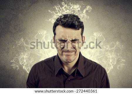 Portrait of Young man thinking too hard .Angry,Stressed man with waving smoke from head.