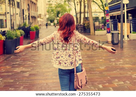 Freedom-Young woman with raised hands in a city.Young woman walking with raised hands feeling free.Life style