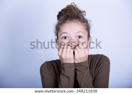 Frightened little girl  with hands over her mouth, over white background.Scared little girl from seeing something.