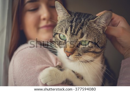 Pets Care.Young woman holding cat home.Cute cat in woman hands.Animal Love.Cat lover.Friendship.