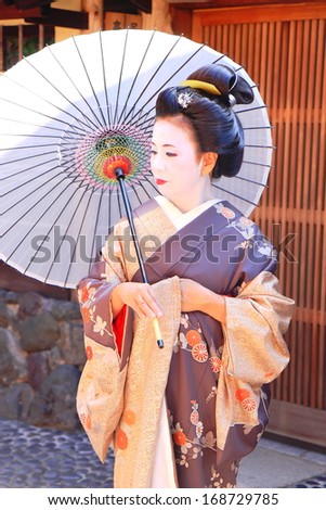 KYOTO,JAPAN - OCTOBER 14:Geisha poses for a photographer with white umbrella on October 14,2013 in Kyoto.