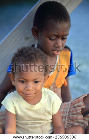 PANGI,VANUATU-OCTOBER 14, 2014: Native boy takes care of his brother while their parents work in a local business on October 14, in Pentecostes-Vanuatu.