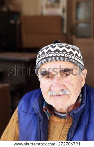 ELMALI,TURKEY-APRIL 05, 2015: Local merchant watches the tourist sitting at the door of his business on April 05, Turkey.