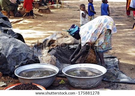 BOBO-DIOULASSO, BURKINA FASO - DECEMBER 31: an old woman cooking local beer made from millet in Burkina Faso called Dolo in the middle of a street in Bobo-Dioulasso, december 31, 2007