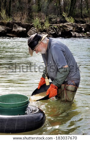 BOUCOIRAN, FRANCE - MARCH 16; Gold digger in France in the region of Cevennes and the department of Gard in the middle of the river called Le Gardon, march 16, 2014