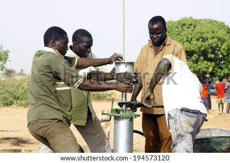 LIGUIDIMALGEM, BURKINA FASO - FEBRUARY 27: installation and assembly of a pump in Burkina Faso funded humanitarian associassion. Workers boarding system manual control surface, February 27, 2007.