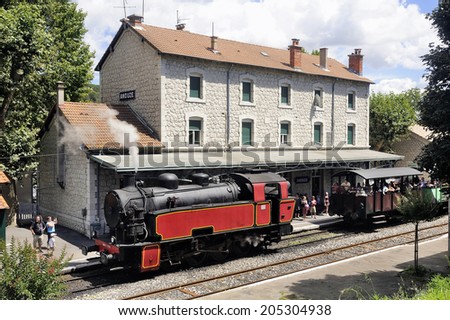 ANDUZE, FRANCE - JULY 14 : The steam locomotive tourist train from Anduze receding to hang cars and from Saint-Jean-du-Gard, July 14, 2014.