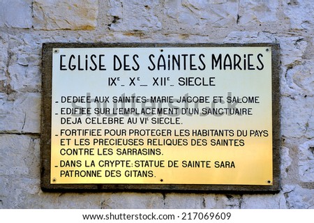 plaque explaining the history of the church of Saintes-Maries-de-la-Mer. Dedicated to Saints Mary Jacobe and Salome and the Crypt containing the statue of Saint Sara patron saint of the Gypsies.