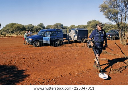 AUSTRALIA - MAY 5: A group of gold miners parked on an Australian track to the point on the map while another seeks a nugget of gold lost in the sector, may 5, 2007.