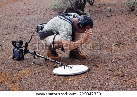AUSTRALIA - MAY 13: The gold miner refine the search by passing the detection handful of soil growing small to find the golden nugget, may 13, 2007.