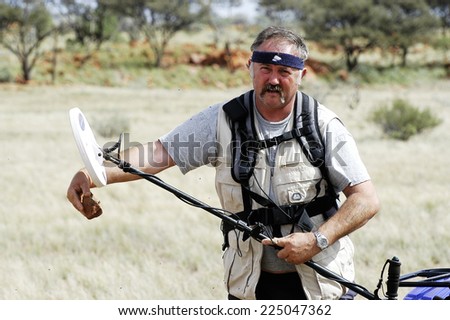 AUSTRALIA - MAY 6: Gold miner in the Australian outback looking to see if a piece of quartz containing gold,  may 6, 2007.