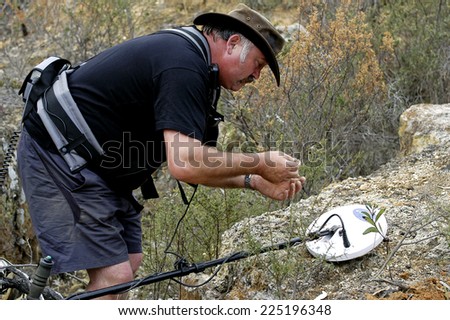 AUSTRALIA - APRIL 24: The gold miner observes his discovery to see if what he found is gold or just iron, April 24, 2007