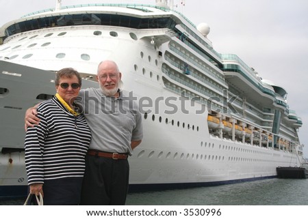 Senior couple ready for another cruise in front of a cruise ship.