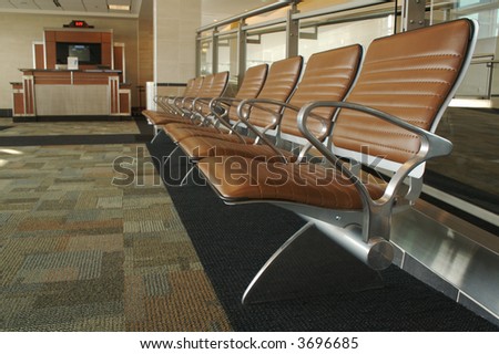 Abstract image of stylish designed waiting room seating and gate desk at an airport.