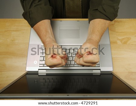 Frustrated businessman shows his frustration while working on his laptop.
