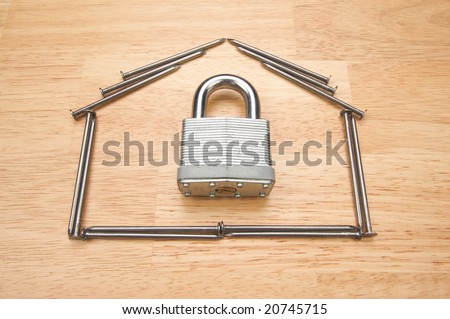House of Nails with Lock on a Wood Background.