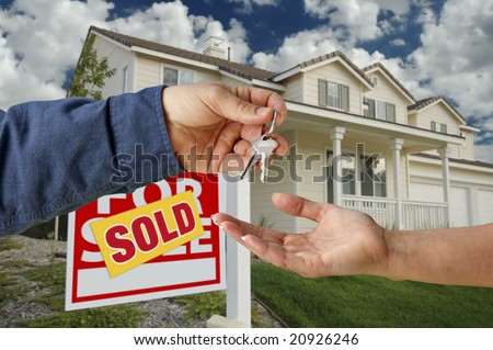 Handing Over the Keys to A New Home with Sold Home For Sale Sign.