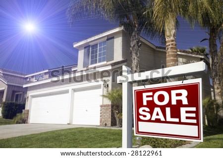 Red For Sale Real Estate Sign in Front of House with Blue Starburst in Sky.