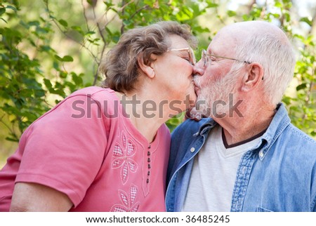 Loving Senior Couple Kissing and Enjoying the Outdoors Together.