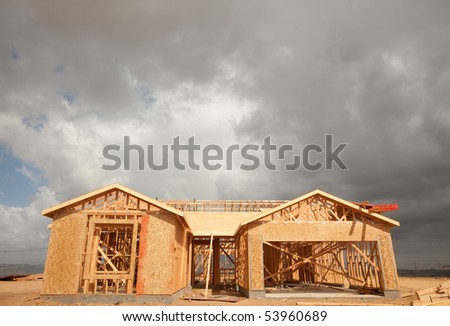 Abstract of New Home Construction Site Framing and Dramatic Clouds Overhead.