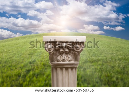 Ancient Replica Column Pillar Over Arched Horizon of Grass and Clouds.