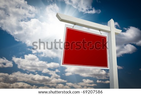 Blank Red Real Estate Sign Over Clouds and Sky Ready For Your Own Message.
