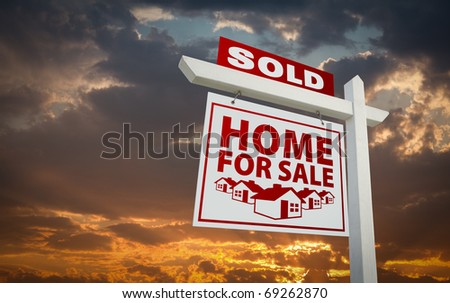 Red Sold Home For Sale Real Estate Sign Over Beautiful Clouds and Sunset Sky.