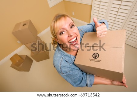 Excited Woman with Thumbs Up and Moving Boxes in Empty Room Taken with Extreme Wide Angle Lens.