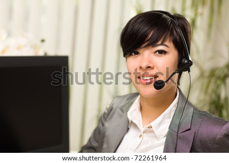 Attractive Young Woman Smiles Wearing Headset Near Her Computer Monitor.