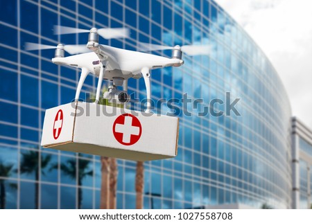 Unmanned Aircraft System (UAS) Quadcopter Drone Carrying First Aid Package Near Corporate Building.