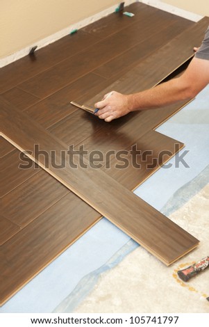 Man Installing New Laminate Wood Flooring Abstract.