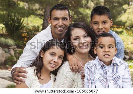 Happy Attractive Hispanic Family Portrait Outdoors In the Park. Happy Attractive Hispanic Family Portrait Outdoors In the Park.
