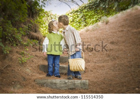 Adorable Brother and Sister Children with Basket Kissing Outside.