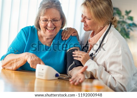 Senior Adult Woman Learning From Female Doctor to Use Blood Pressure Machine.