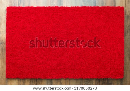 Blank Red Welcome Mat On Wood Floor Background Ready For Your Own Text.