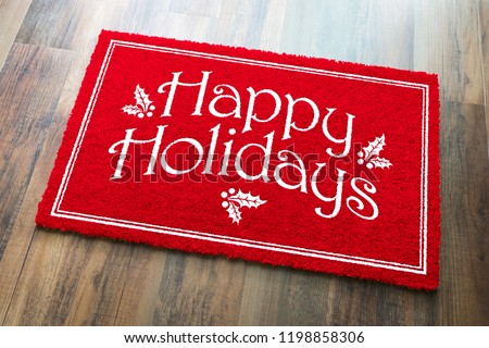 Happy Holidays Christmas Red Welcome Mat On Wood Floor Background.