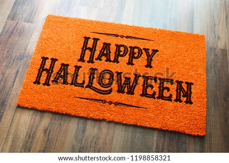 Happy Halloween Orange Welcome Mat On Wood Floor Background.