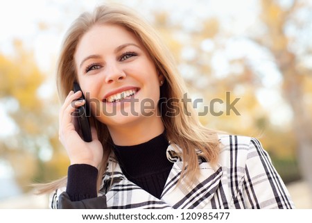 Pretty Young Blond Woman on Her Cell Phone Outside on Fall Day.
