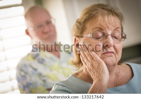 Senior Adult Couple in Dispute or Consoling in Kitchen of House.