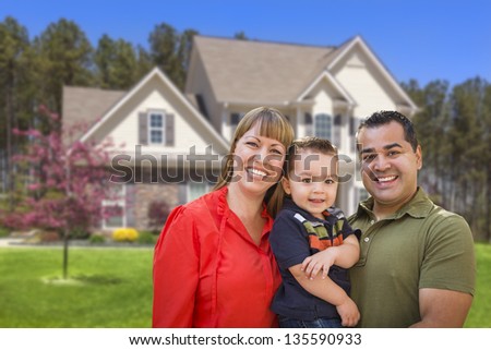 Happy Mixed Race Young Family in Front of Beautiful House.