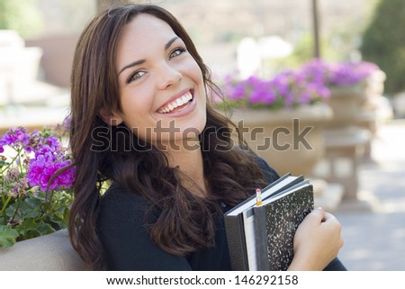 Portrait  of Pretty Young Female Student Carrying Books on School Campus.